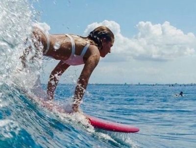 サーフィンで波に乗る女性
